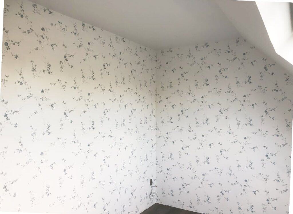 Sort, hvidmeleret væg med blomsterprint mønster - Svane Maler.